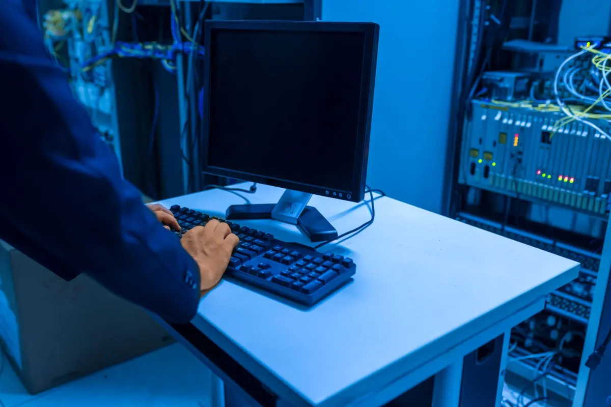 Technicien controlant des equipements dans une salle de serveurs.
